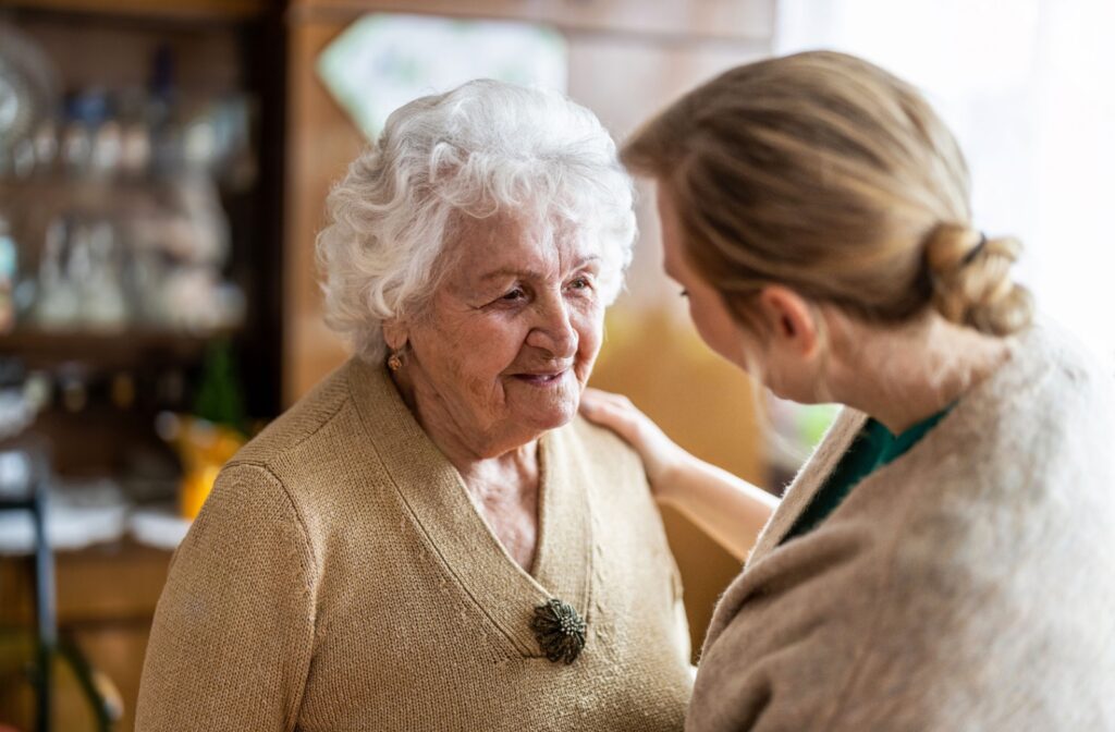 A senior speaking to a caregiver in a memory care community.