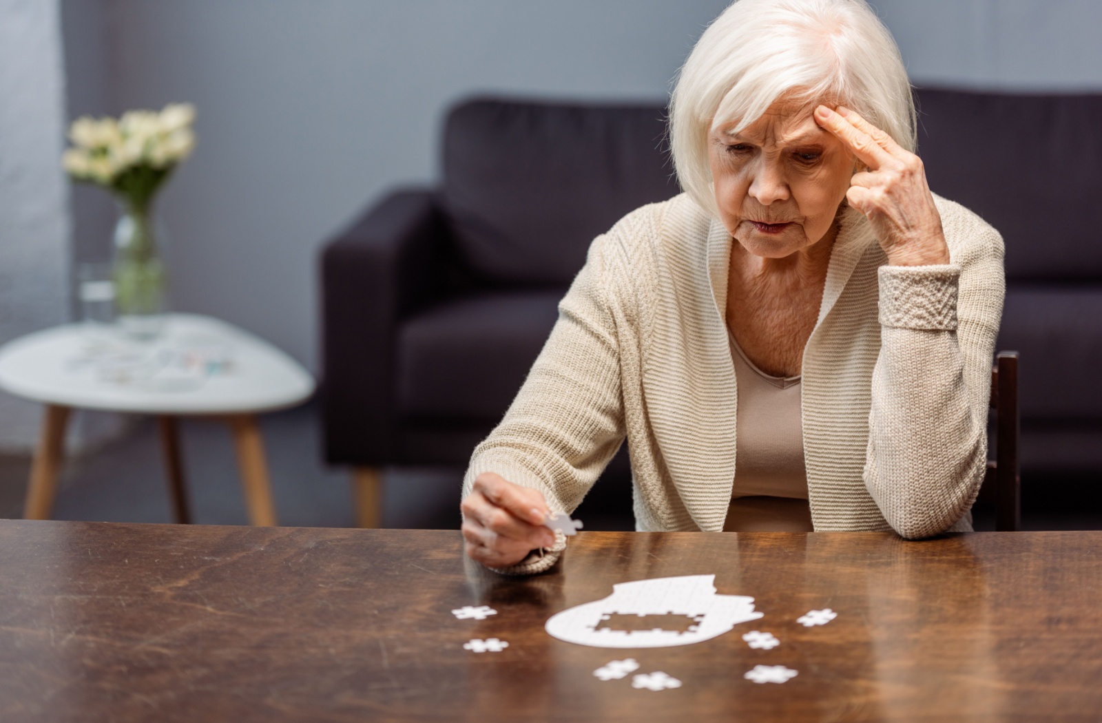 An older adult focuses on her puzzle to help stimulate cognitive function.