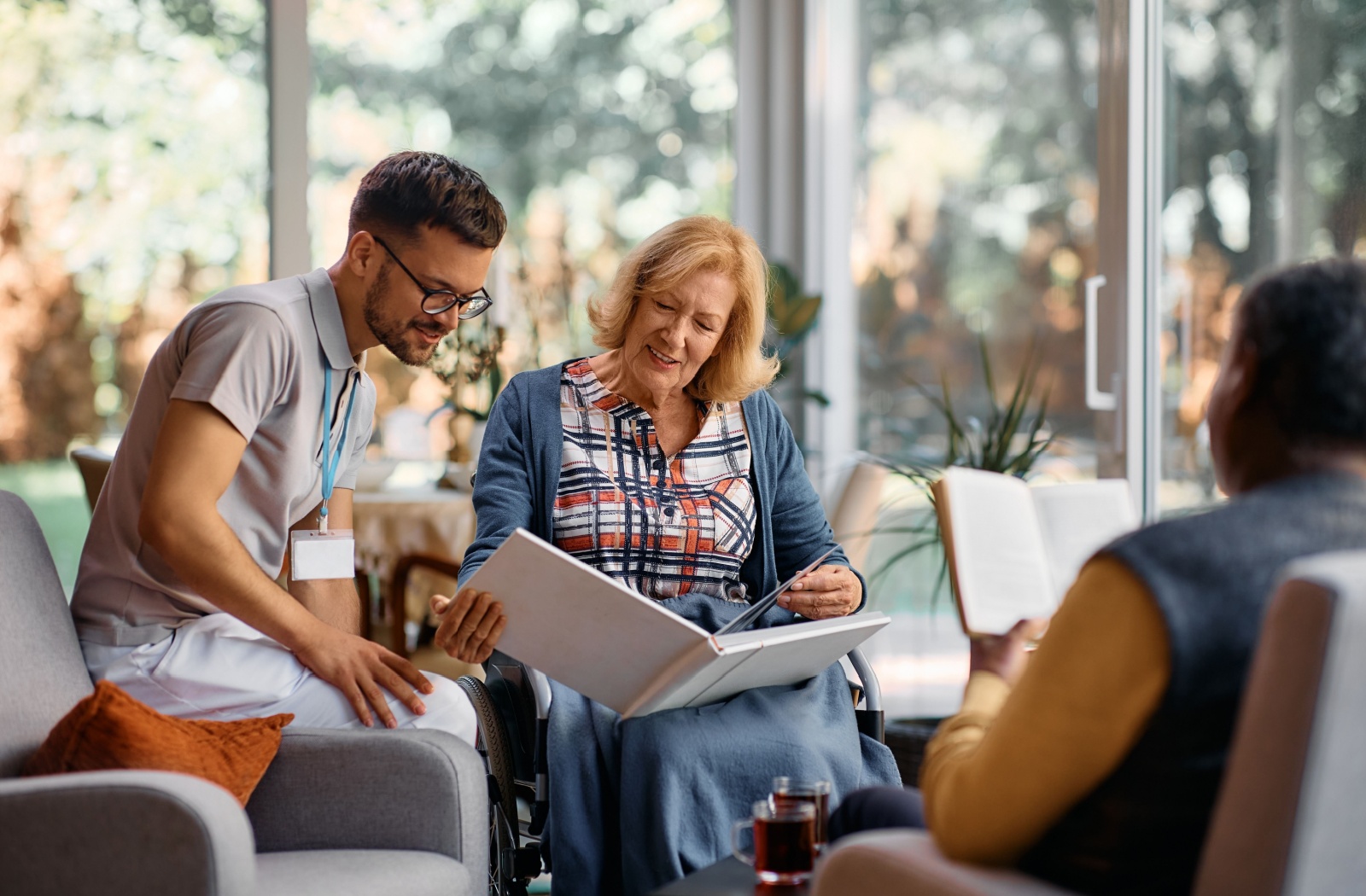 A nurse at a memory care community chatting and looking at photos with it's residents