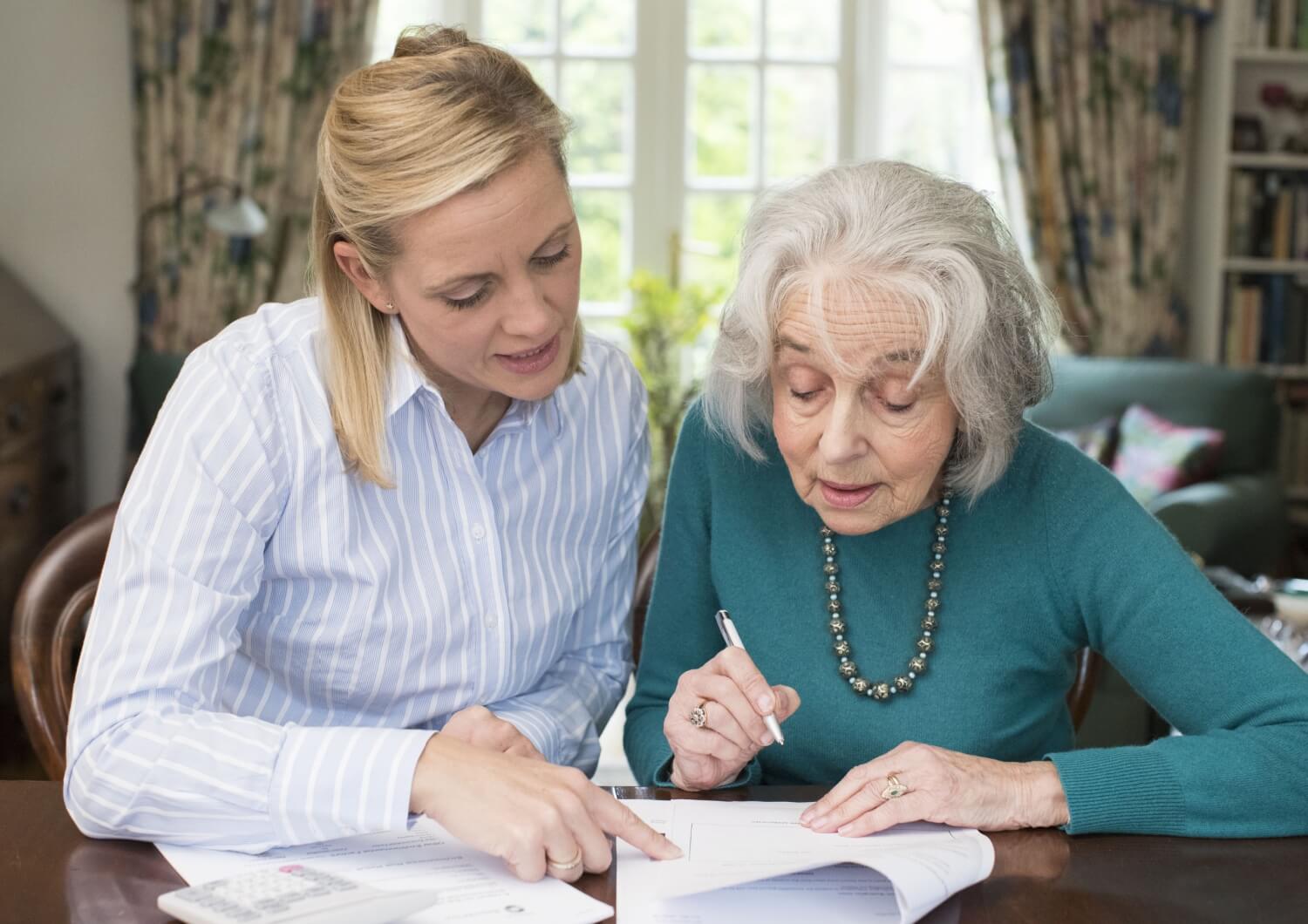 Daughter helping her senior mother review the costs of memory care.