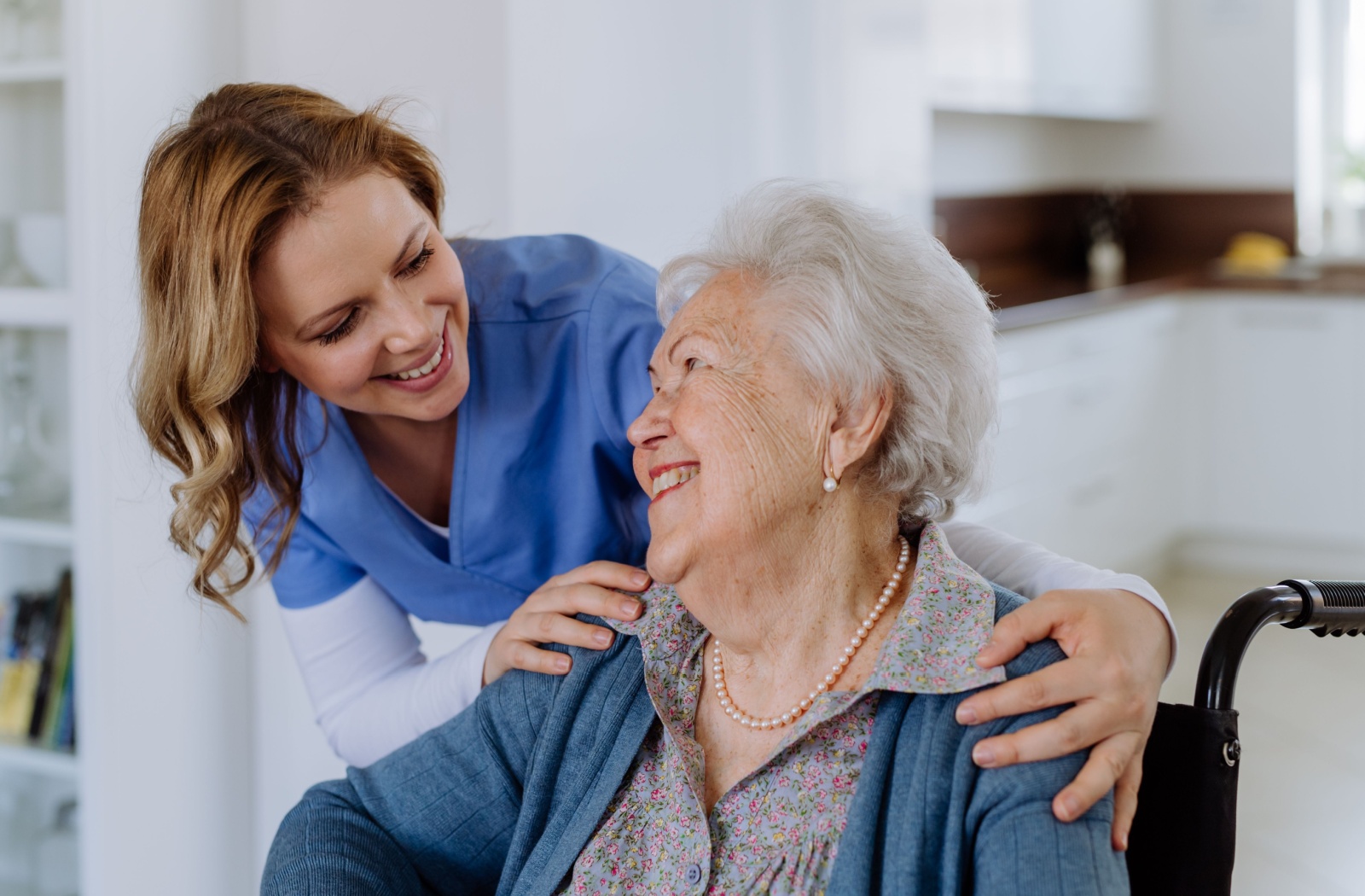 A smiling caregiver checking in on a happy new resident in respite care.