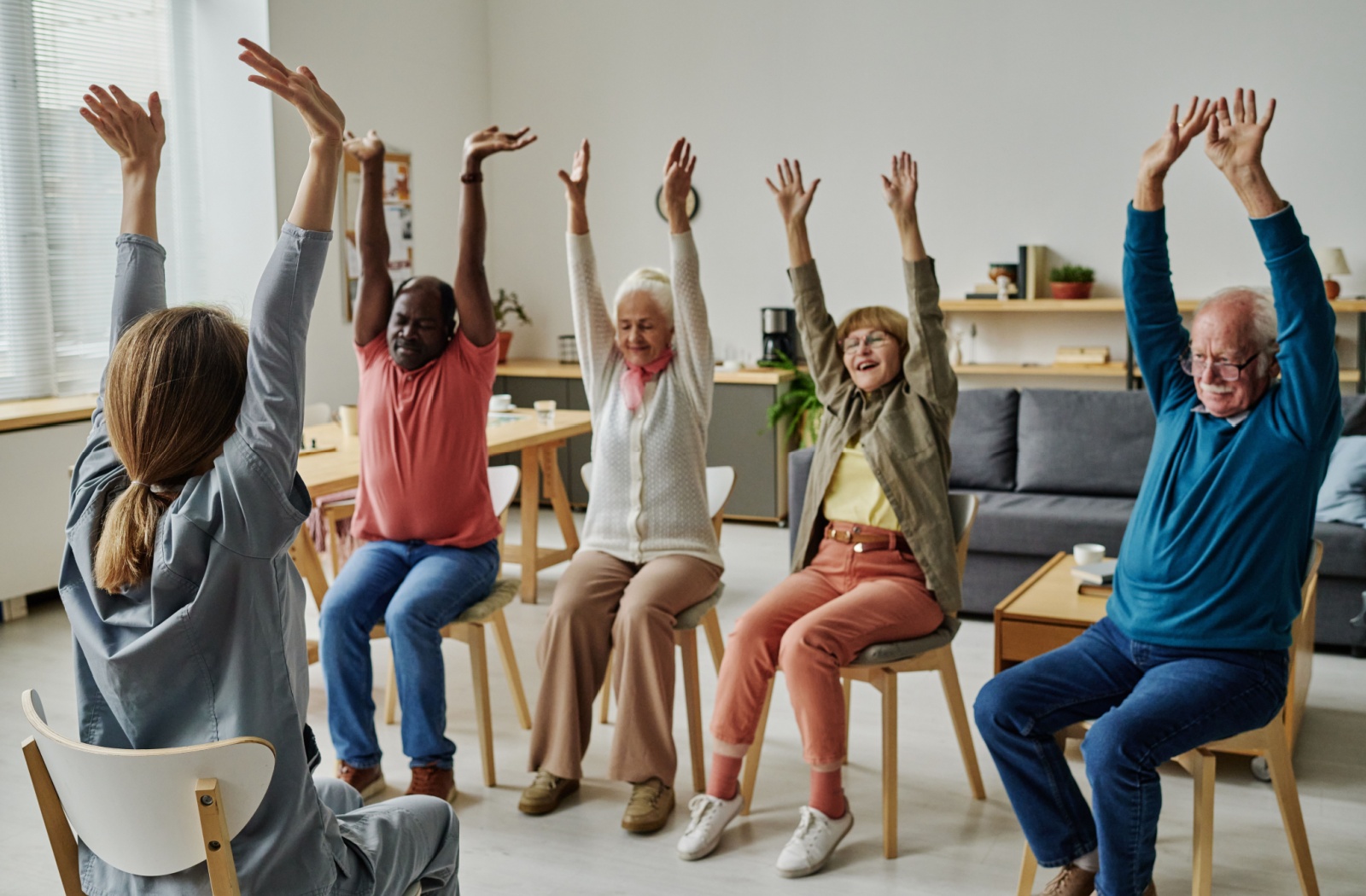 a group of seniors doing chair yoga