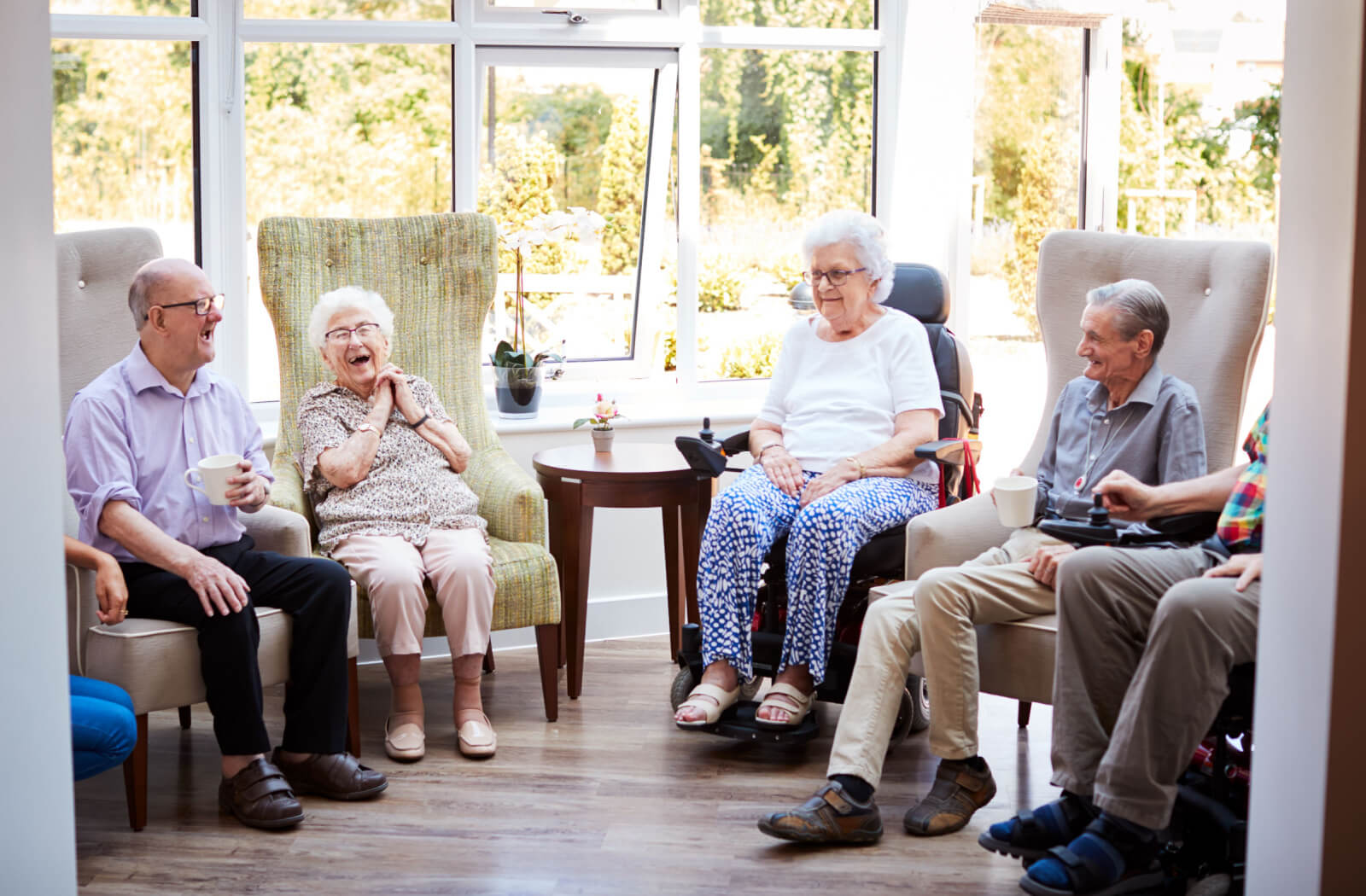 a group of seniors sitting and chatting in memory care